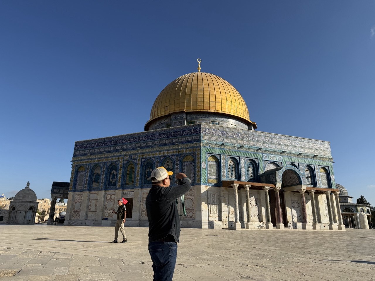 Dome of the Rock dari pelataran, pria bertongkat berdiri menatap kubah.