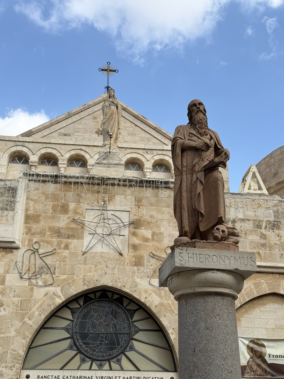 Patung S. Hieronymus di depan Gereja St. Katarina, kompleks Kelahiran, buku di tangan, tengkorak di kaki.