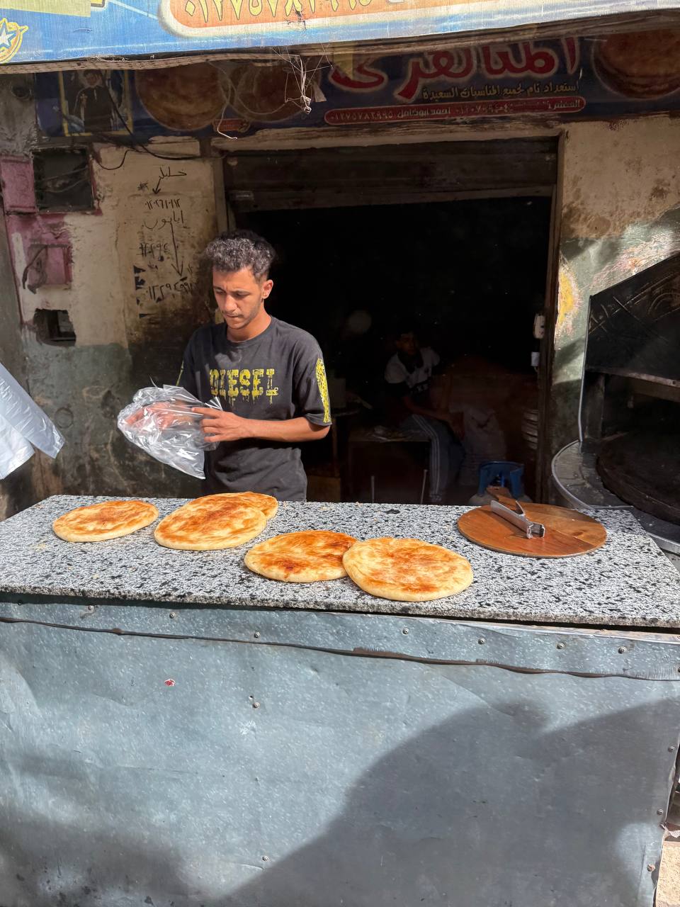 Penjual makanan di kampung miskin Kairo, roti baladi keemasan.