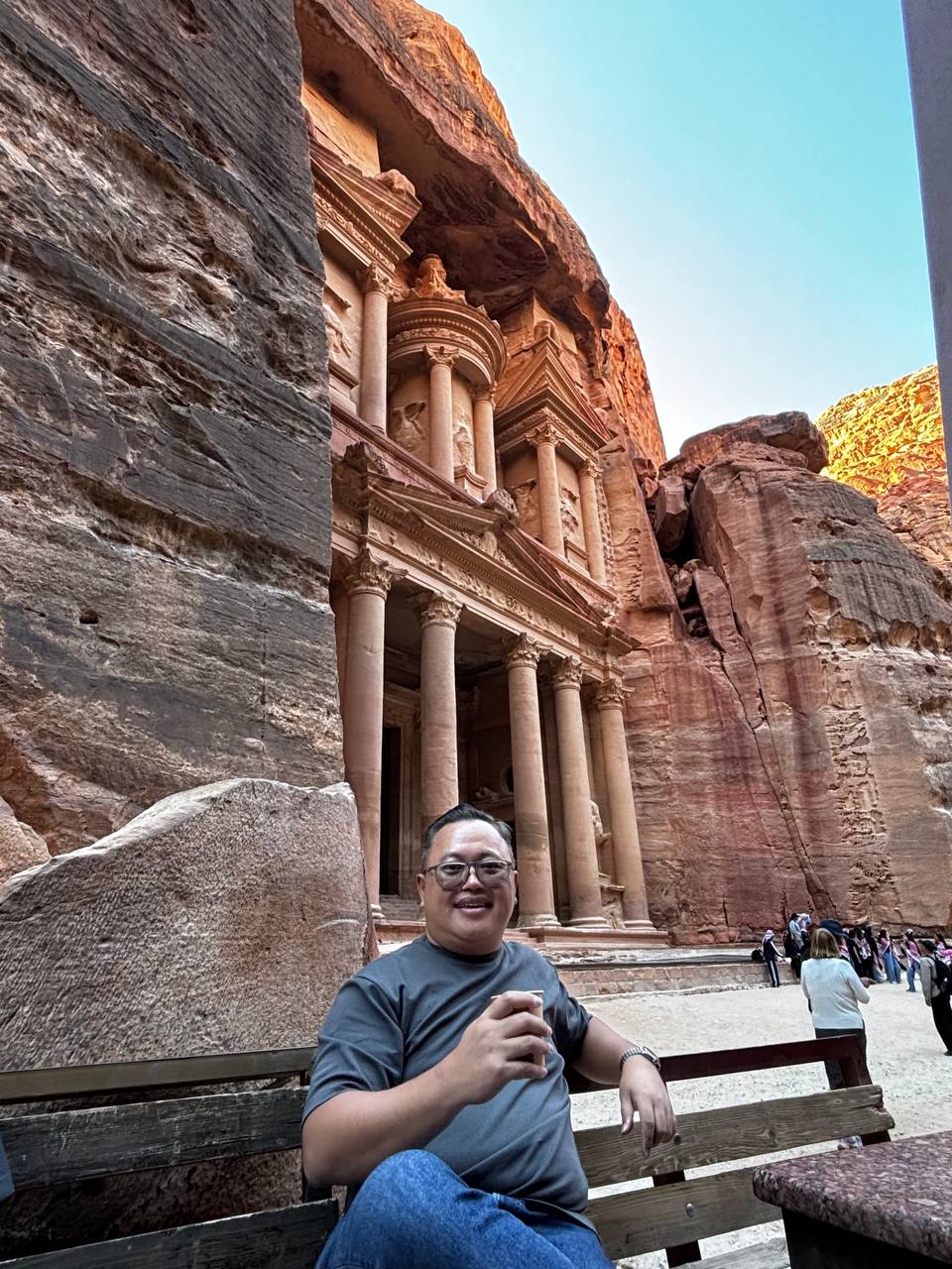 Treasury dari dekat, duduk di bangku kayu, kopi Bedouin di tangan, fasad raksasa menjulang di belakang: grand dan majestic, kata semua buku.